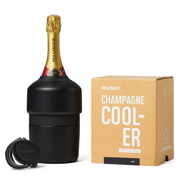 Black champagne cooler with a bottle of champagne and its packaging on a white background