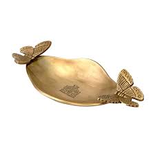 Gold-colored decorative object with butterfly designs on a white background